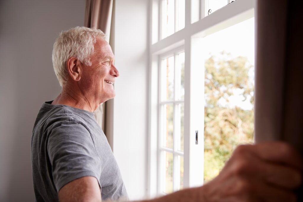 Hillcrest | Man Looking Out The Window In The Morning